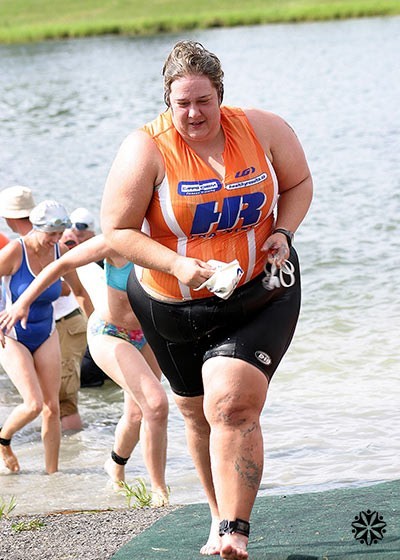 Plus size woman athlete existing the swim in a triathlon race